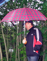 Mann sucht Schutz unterm Regenschirm © Foto: Sylvia Krell (LASA)