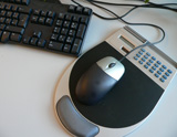 Mousepad mit Taschenrechner vor einer Computertastatur