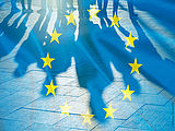 Transparent gehaltene EU-Flagge mit den Schatten einer in einer Gruppe stehenden Menschen © Foto: AdobeStock: Savvapanf Photo