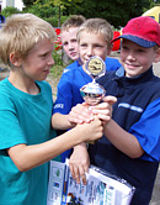 Junge Schüler halten einen Pokal für den Sieg in einem Mannschaftswettkampf in den Händen © Foto: ILB/Sylvia Krell