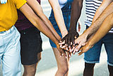Mehrere Menschen mit unterschiedlichen Hautfarben halten ihre Hände vereint übereinander (Quelle AdobeStock: Xavier Lorenzo)