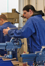 Junge Männer erlernen die Grundlagen der Metallverarbeitung an einer Werbank mit Schraubstöcken © Foto:Elke Mocker