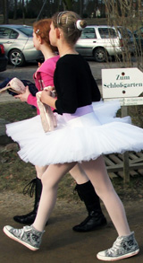 Zwei junge Mädchen laufen im Balettkostüm und Turnschuhen zu ihrem Auftritt. In der Hand halten Sie ihre Balettschuhe © Foto: Sylvia Krell
