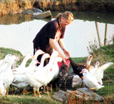Junge Bäuerin beim Füttern von Gänsen und Enten © Foto: Sylvia Krell (LASA)